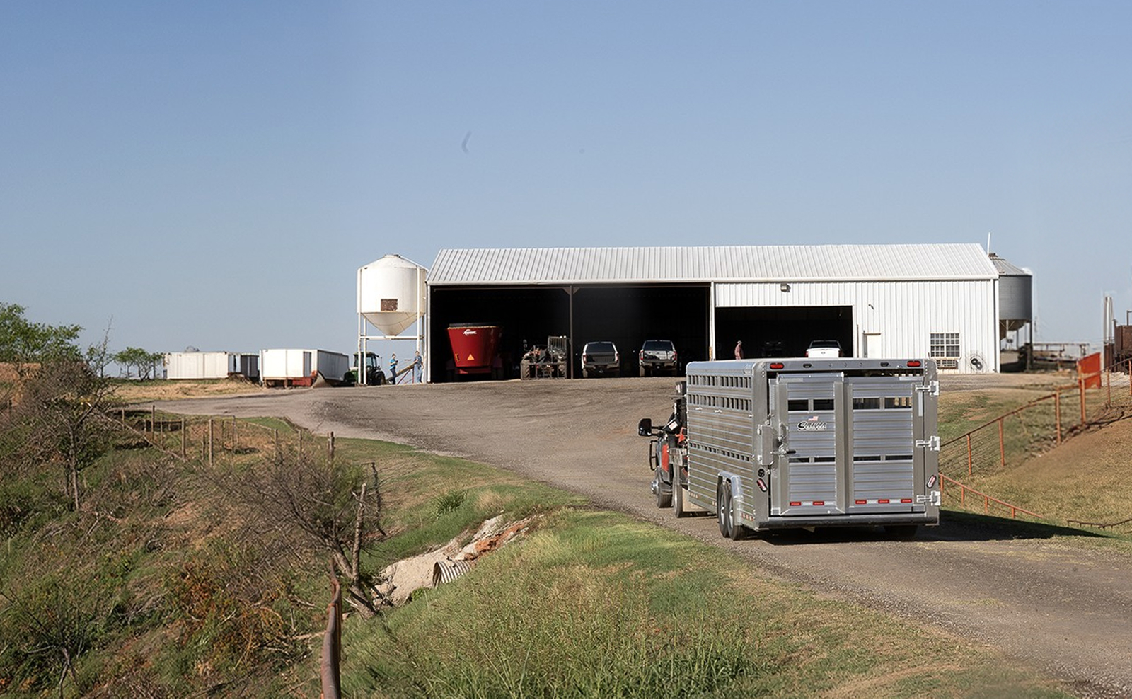 Cattle trailer pulling up to a farm